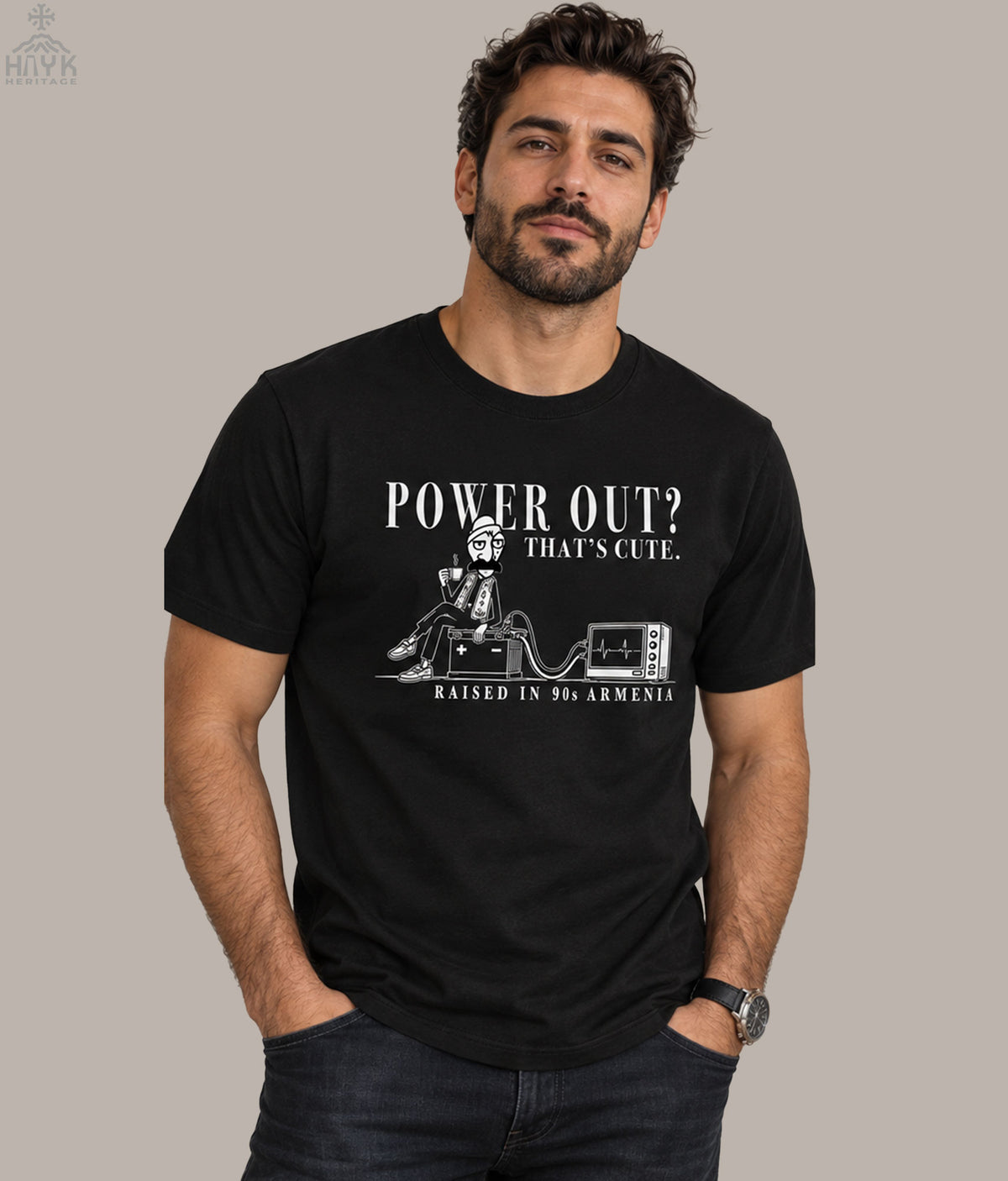 Armenian diaspora humor tee: Norek Aram sipping coffee beside a car battery powering a TV during a blackout, "Raised in 90s Armenia" caption.